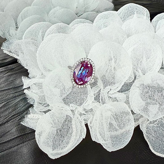 Styled shot of a Future Spark ring, its unique gemstone and silver-toned band artfully presented on a textured bubble white surface, creating an atmosphere of modern, artistic expression.