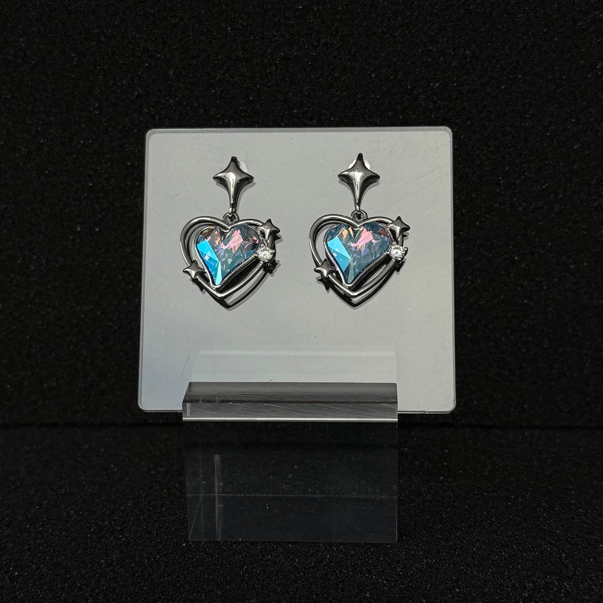 The 'Cyber Tear' variant of Future Spark's Zephyra Heart Earrings, featuring a captivating mix of cybernetic blue and pink tones that give the heart gemstone a liquid, futuristic sheen.
