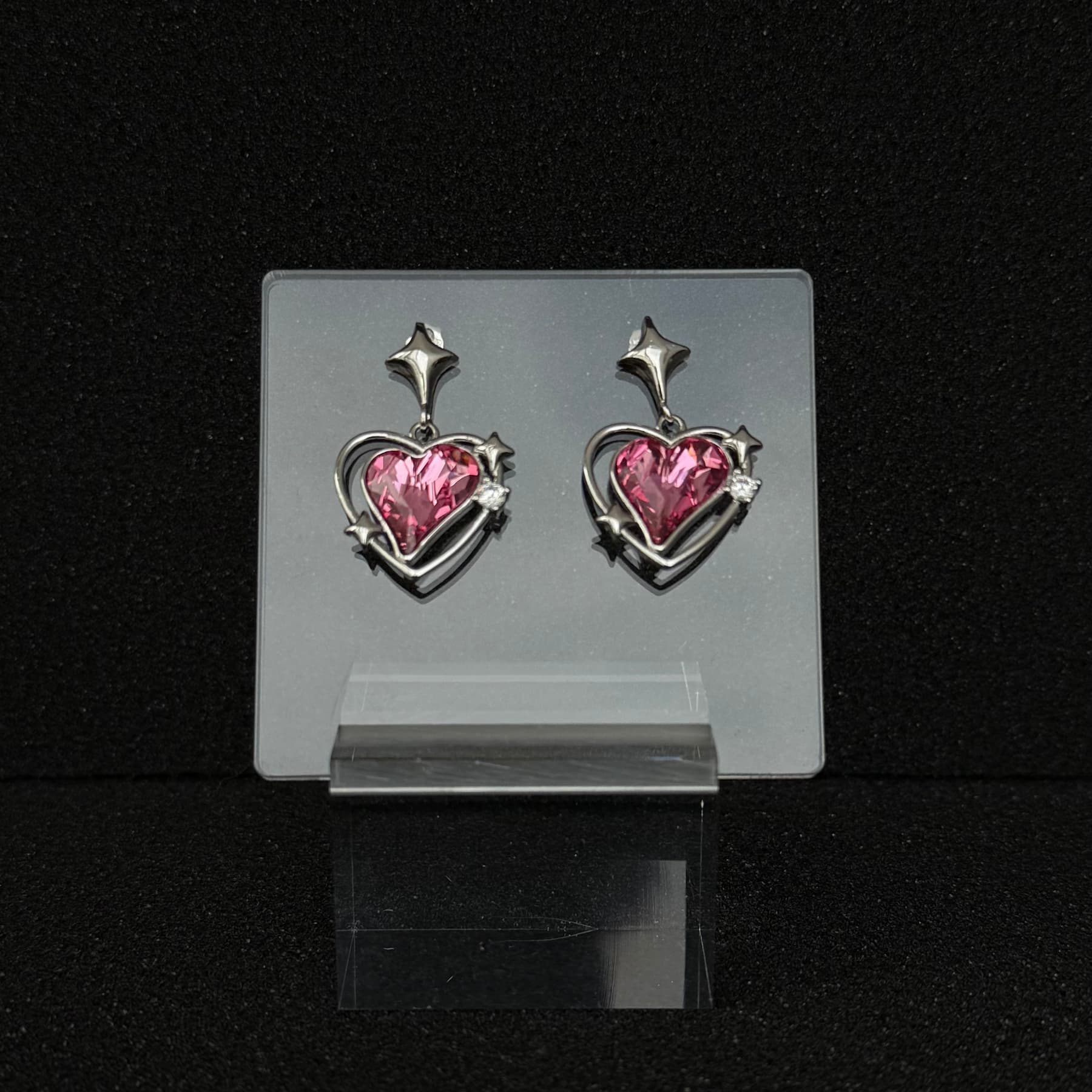 The 'Nebula Rose' variant of Future Spark's Zephyra Heart Earrings, featuring a heart-shaped gemstone with a deep, magenta-rose color reminiscent of a cosmic nebula, in a futuristic silver setting.