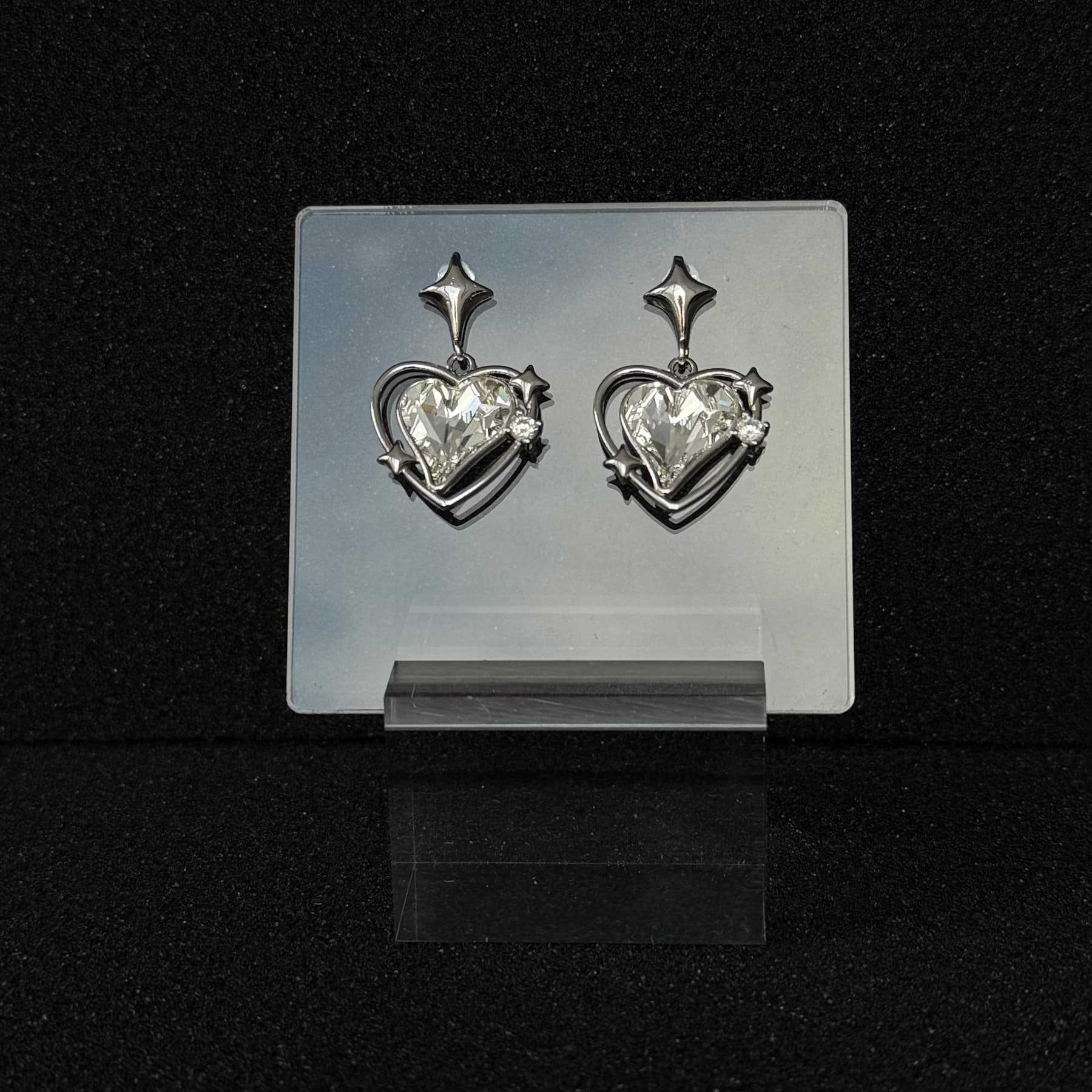 Future Spark Zephyra Heart Earrings in 'Luminous Void', showcasing the heart gemstone's brilliant white luminosity that creates a captivating, void-like contrast against its sleek silver setting.