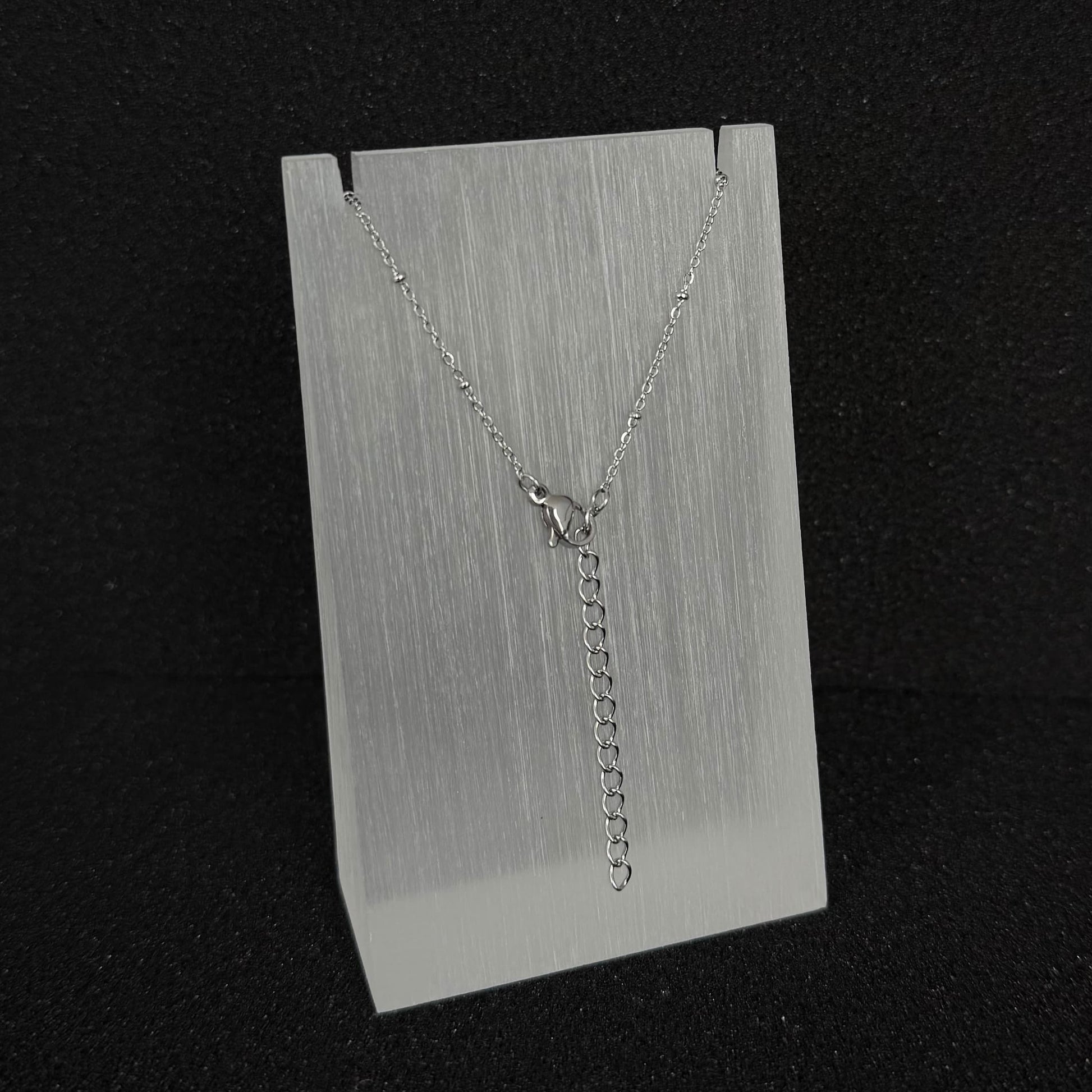 Close-up detail of the adjustable extender chain and clasp on a Future Spark silver-toned necklace, allowing for versatile length options.