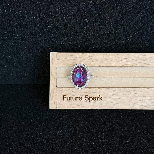 Future Spark's Elune Oval Gemstone Ring in 'Cosmic Ember', showcasing an oval gemstone with a rich, grape-like purple hue that seems to hold a warm, ember-like glow from within, set in sleek silver.