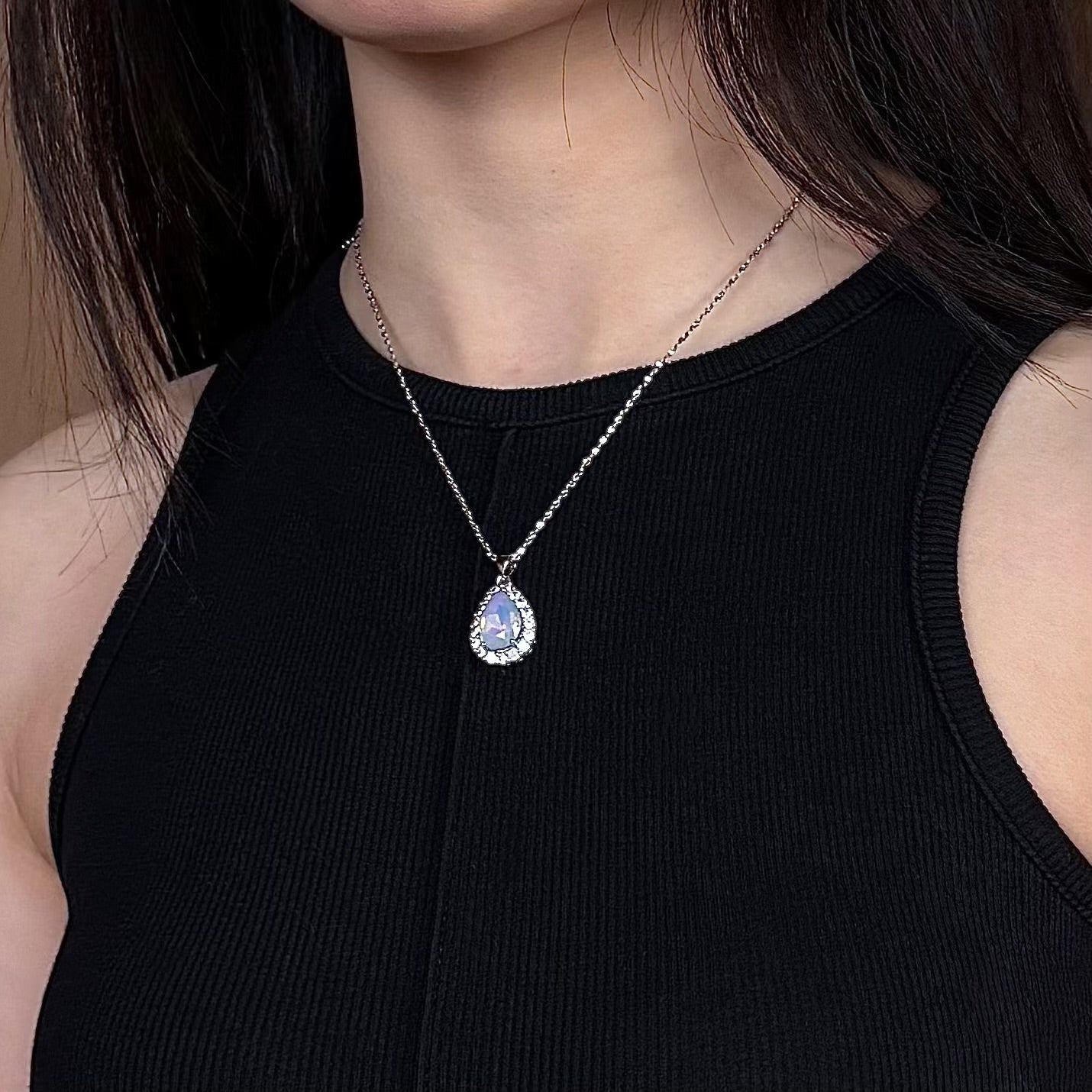 Model wearing Future Spark's Nyra Teardrop Pendant, highlighting the sparkling gemstone and silver-tone jewelry as an elegant, eye-catching accessory.