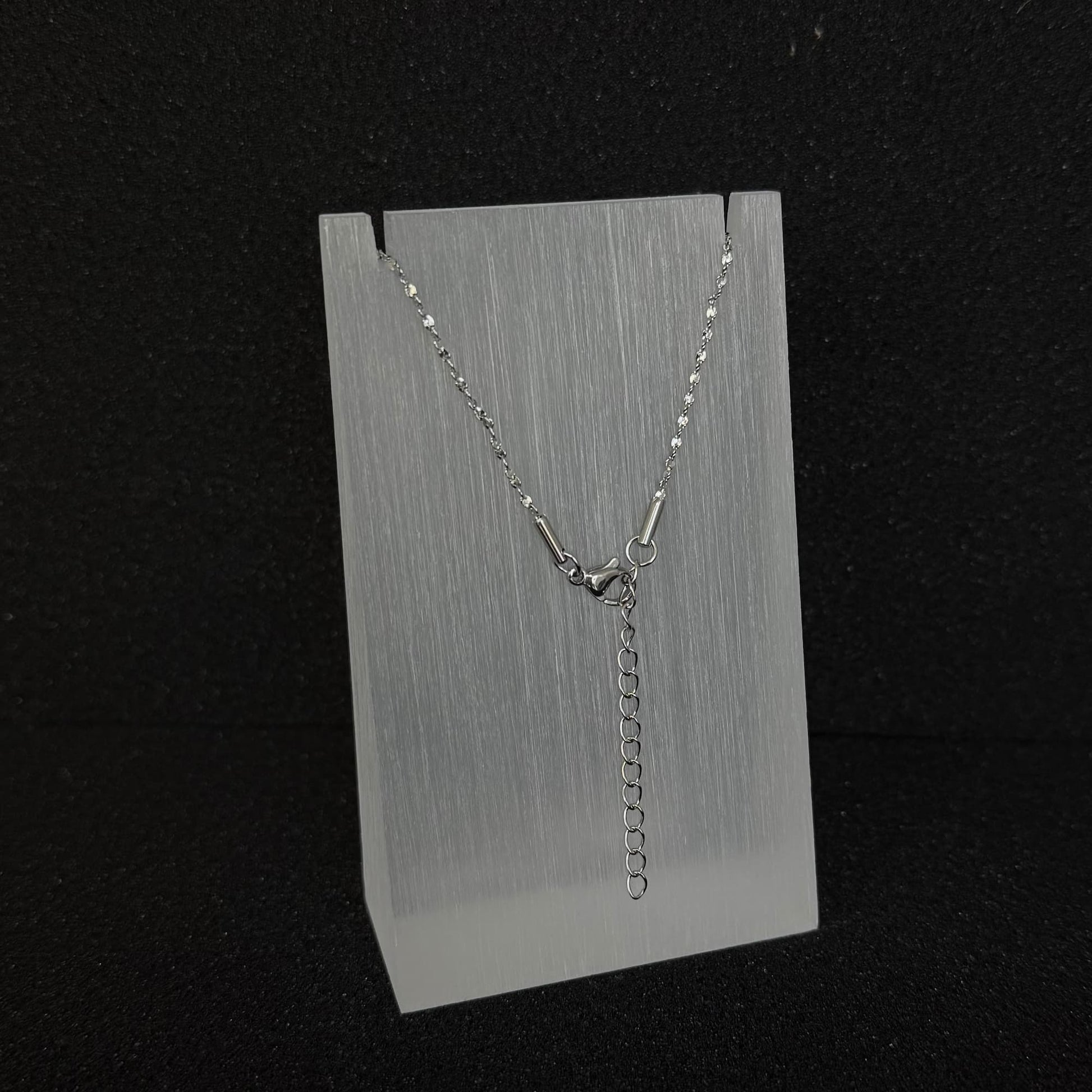 Close-up detail of the adjustable clasp and extender chain on a Future Spark silver-toned necklace, allowing for versatile length adjustment.