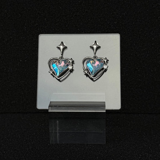 The 'Cyber Tear' variant of Future Spark's Zephyra Heart Earrings, featuring a captivating mix of cybernetic blue and pink tones that give the heart gemstone a liquid, futuristic sheen.